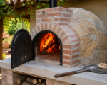 Horno Mediterráneo de leña encendido para cocinar pizzas y asados en jardín